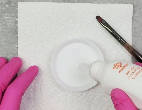 Take the brush cleaner and add about 10-15 drops onto a shallow nail art dish.